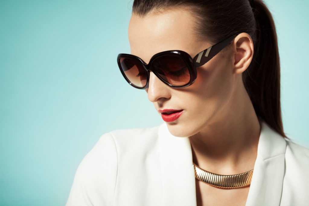 A woman wearing sunglasses and a necklace.