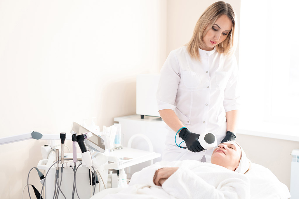 A woman in white shirt holding hair dryer near man.